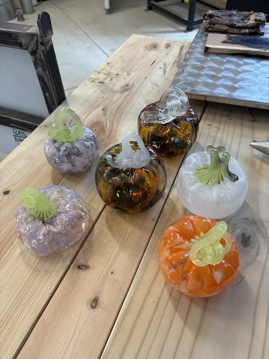 A table of glass pumpkins in lavender, amber, white and orange by Caroline Abbey