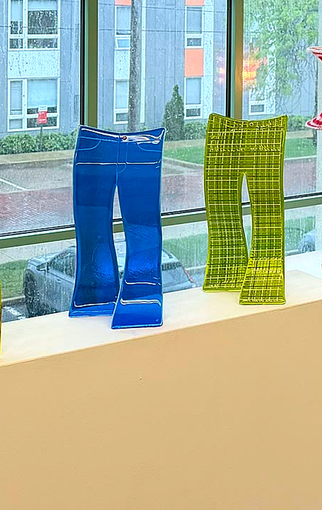 Blue and green glass pants displayed on a gallery pedestal